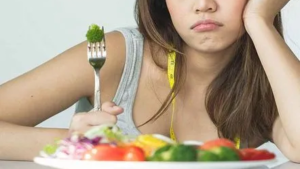 Person experiencing loss of appetite and fatigue due to health imbalance