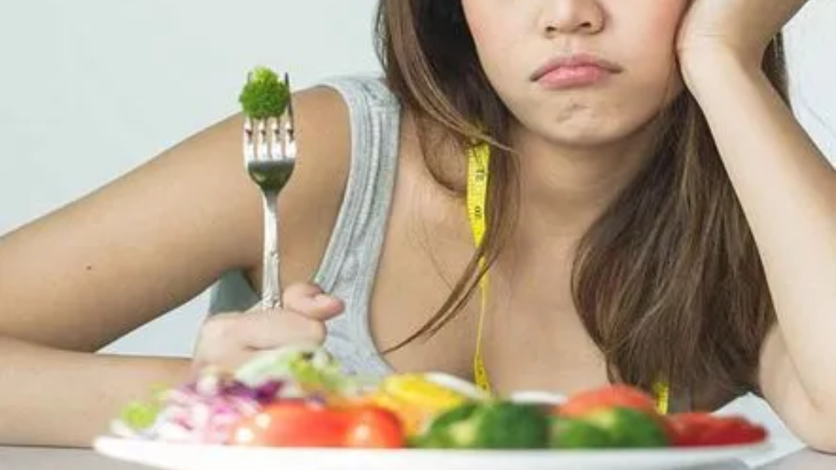 Person experiencing loss of appetite and fatigue due to health imbalance