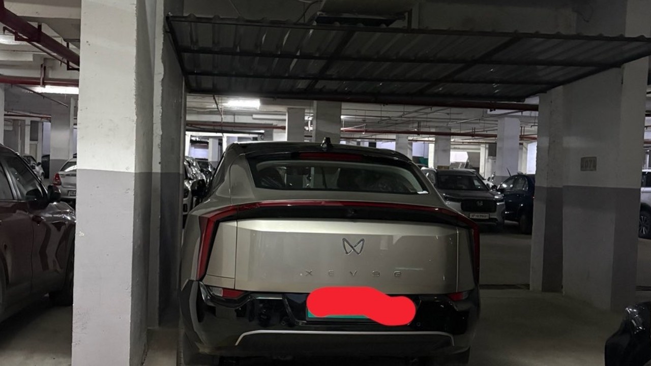 Mahindra XEV 9e parked in an apartment complex with a quote