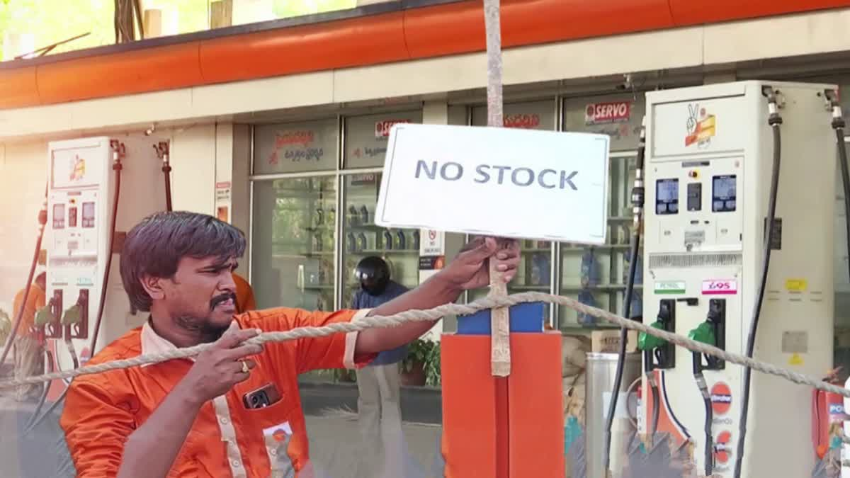 పెట్రోల్ బంకు వద్ద ఇంధనం కోసం వేచి ఉన్న వాహనదారులు మరియు 'నో స్టాక్' బోర్డు.