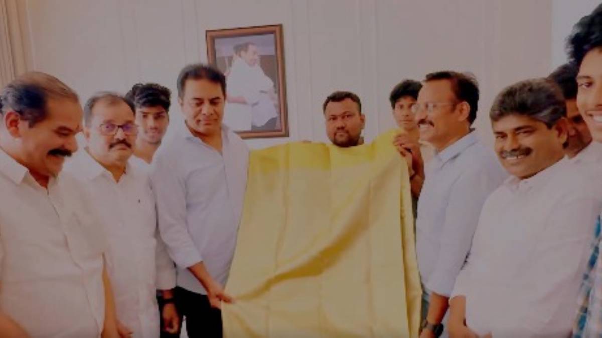 BRS leader KTR showcasing the golden saree created by Sircilla weaver Nalla Vijay using 2 grams of gold and silver.